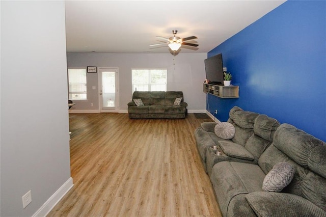 living area featuring baseboards, wood finished floors, and ceiling fan