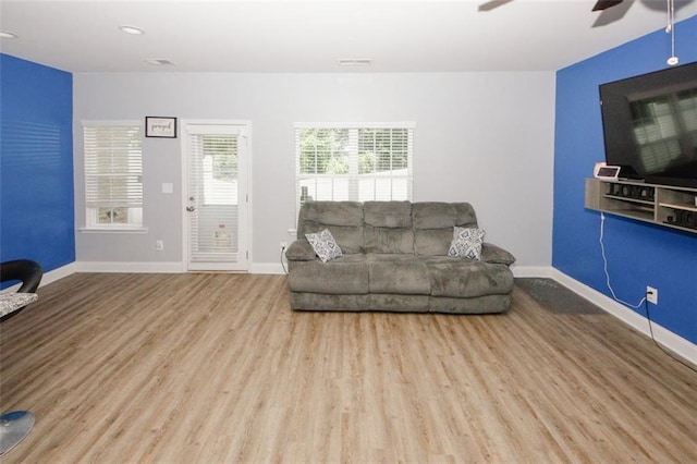 living room featuring ceiling fan, wood finished floors, and baseboards