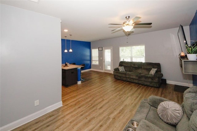 living room featuring baseboards, ceiling fan, wood finished floors, and recessed lighting