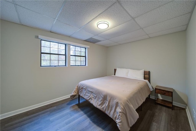 bedroom featuring a drop ceiling and wood-type flooring