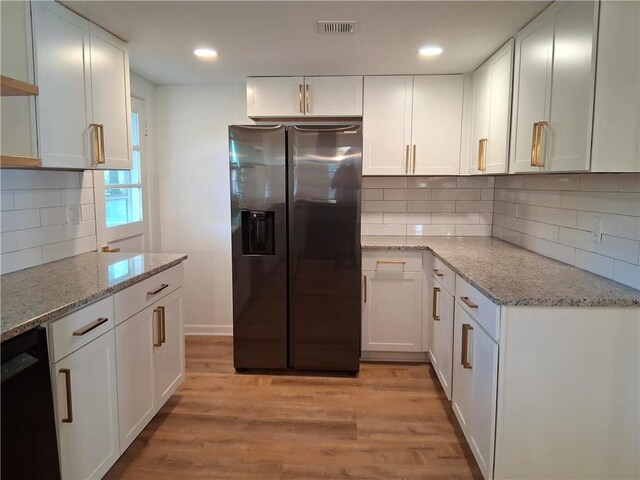 816 Stewart St, Carrollton, GA 30117 - kitchen with stainless steel fridge, white cabinets, backsplash, and light wood-type flooring