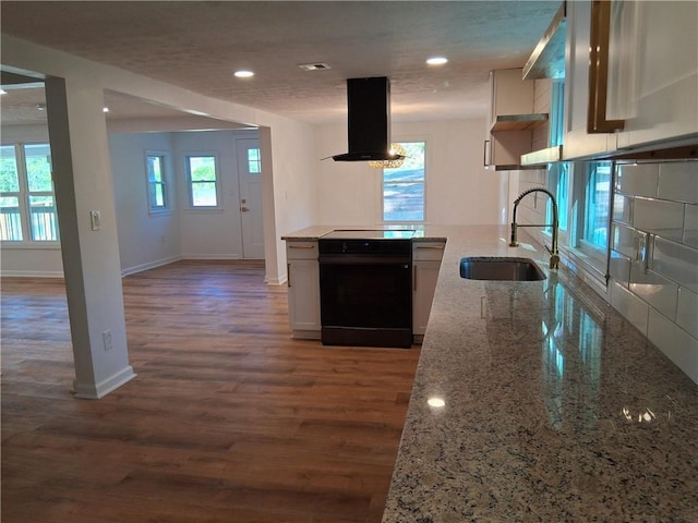 816 Stewart St, Carrollton, GA 30117 - kitchen featuring light stone counters, a sink, island range hood, baseboards, and electric range