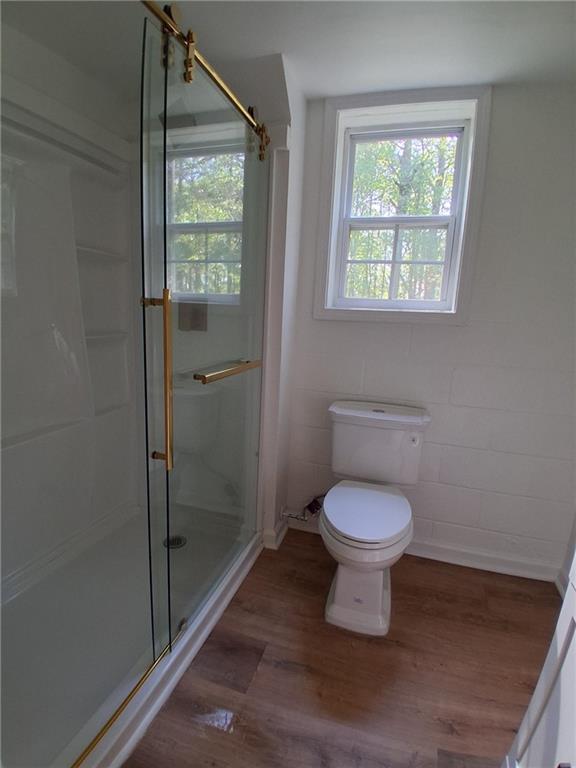 816 Stewart St, Carrollton, GA 30117 - full bath featuring wood finished floors, a shower stall, and toilet