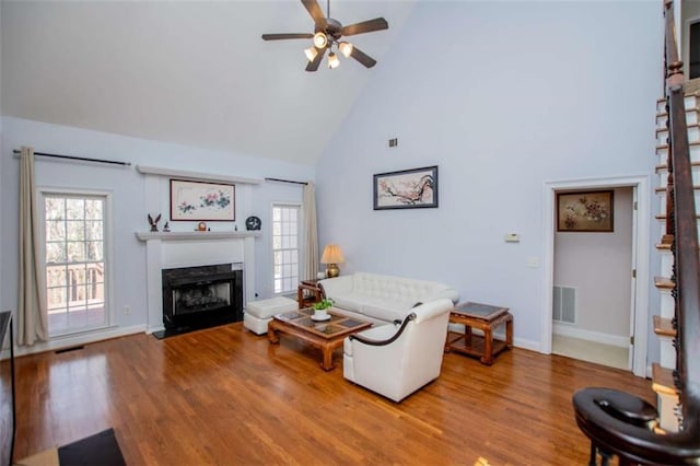 2003 Hubbard Ct, Villa Rica, GA 30180 - living area featuring high vaulted ceiling, healthy amount of natural light, ceiling fan, wood finished floors, and a fireplace with flush hearth