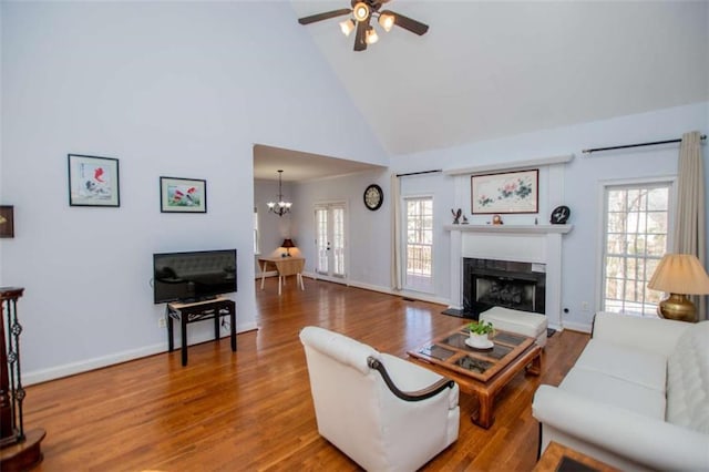 2003 Hubbard Ct, Villa Rica, GA 30180 - living area featuring a fireplace with raised hearth, a ceiling fan, high vaulted ceiling, healthy amount of natural light, and a chandelier