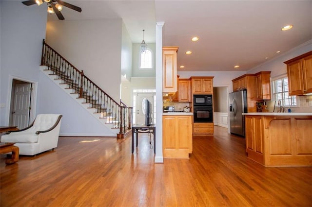 2003 Hubbard Ct, Villa Rica, GA 30180 - kitchen featuring black appliances, open floor plan, a ceiling fan, light wood-type flooring, and a towering ceiling