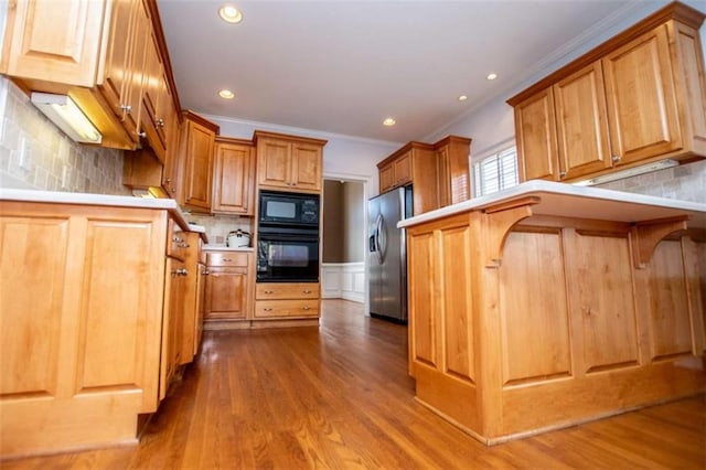 2003 Hubbard Ct, Villa Rica, GA 30180 - kitchen with black appliances, crown molding, tasteful backsplash, wood finished floors, and brown cabinetry
