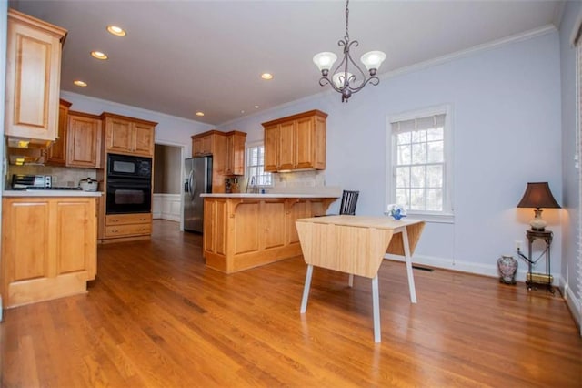 2003 Hubbard Ct, Villa Rica, GA 30180 - kitchen with black appliances, backsplash, a peninsula, a chandelier, and crown molding
