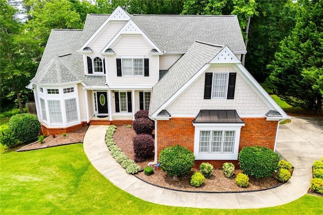 2003 Hubbard Ct, Villa Rica, GA 30180 - view of front of home featuring brick siding, a front lawn, a standing seam roof, and roof with shingles