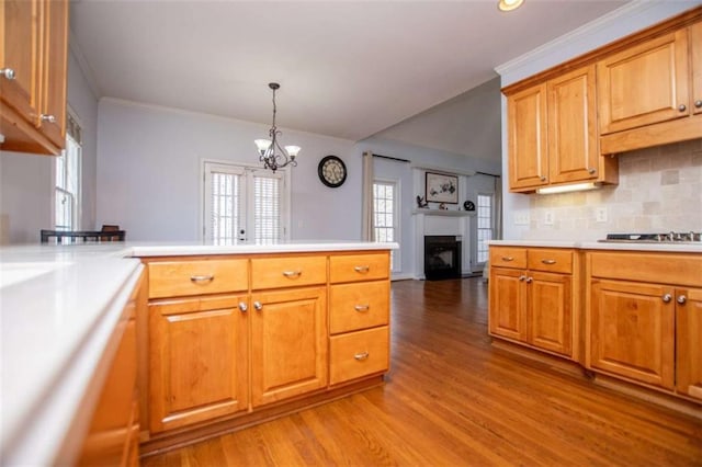 2003 Hubbard Ct, Villa Rica, GA 30180 - kitchen with a fireplace, a peninsula, crown molding, light wood-style floors, and light countertops