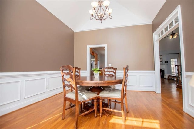 2003 Hubbard Ct, Villa Rica, GA 30180 - dining area with vaulted ceiling, light wood-style flooring, a chandelier, wainscoting, and a decorative wall