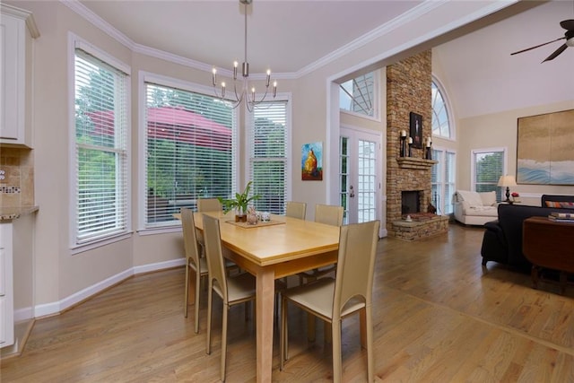 130 Hamilton Way, Roswell, GA 30075 - dining room featuring light wood-style floors, a stone fireplace, ceiling fan, a chandelier, and crown molding