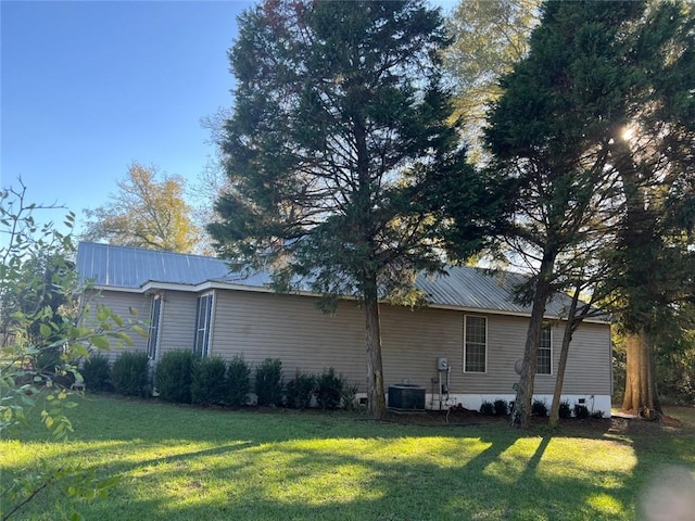 view of side of property featuring a yard and cooling unit