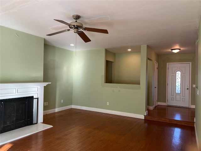 unfurnished living room with ceiling fan and dark wood-type flooring