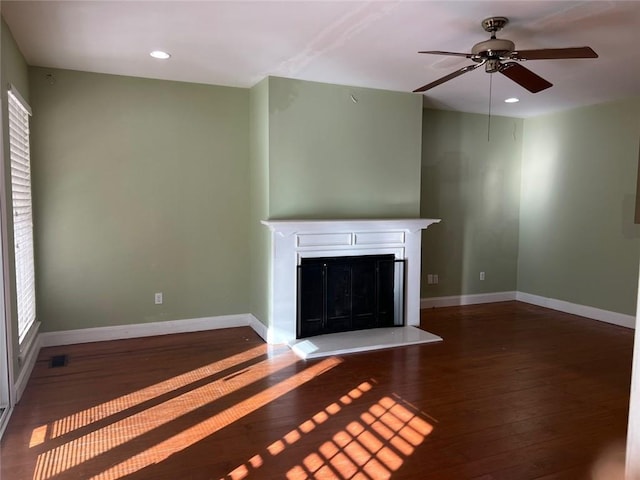 unfurnished living room with ceiling fan and dark wood-type flooring