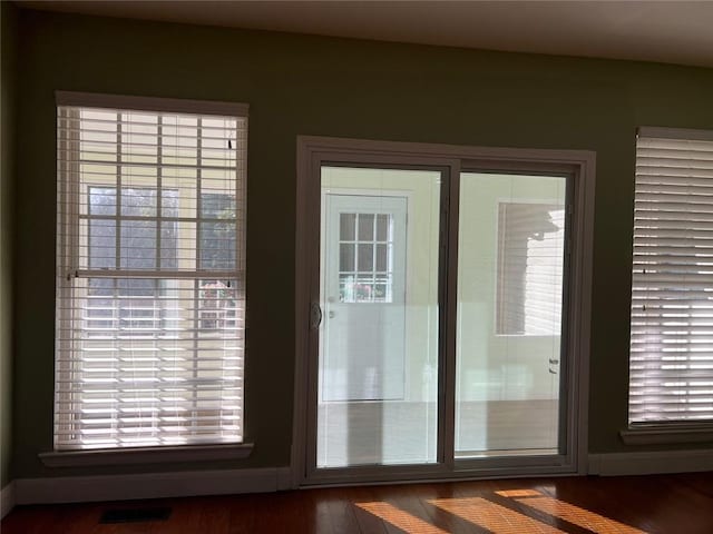 doorway to outside featuring dark wood-type flooring