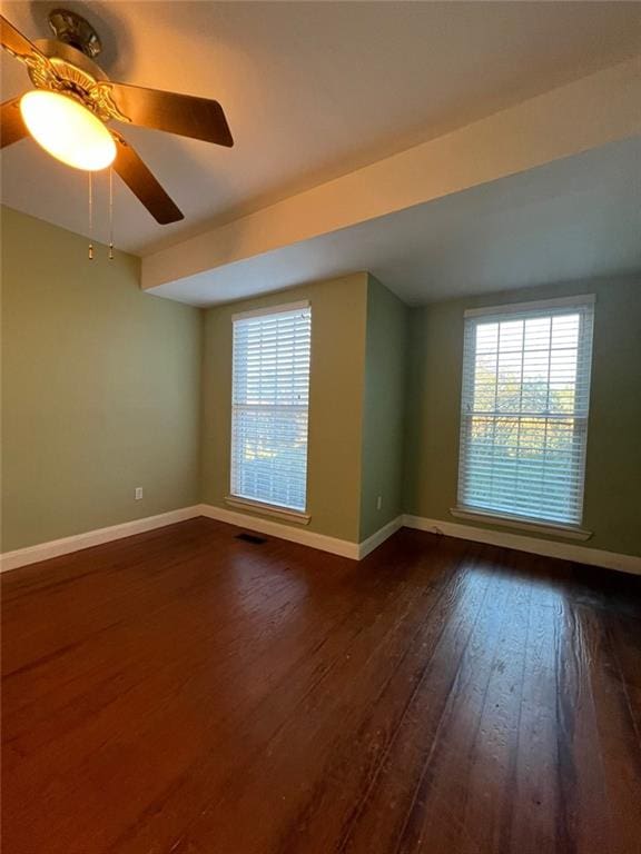 unfurnished room with ceiling fan and dark hardwood / wood-style flooring