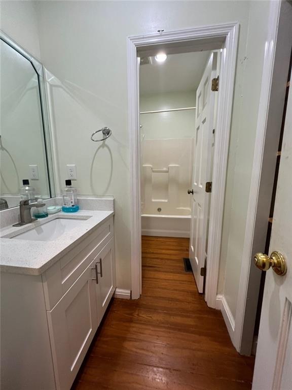 bathroom featuring shower / bath combination, vanity, and wood-type flooring