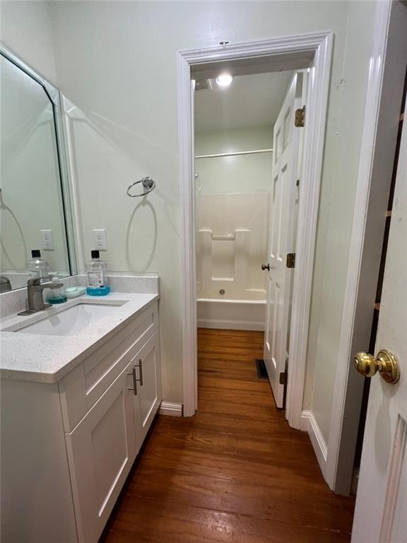 94 Cedar Valley Rd, Montezuma, GA 31063 - full bathroom with vanity, wood finished floors, tub / shower combination, and baseboards