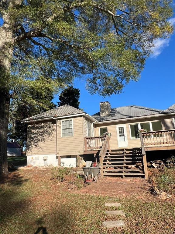 rear view of property featuring a wooden deck