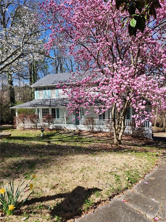 obstructed view of property with a porch and a front yard