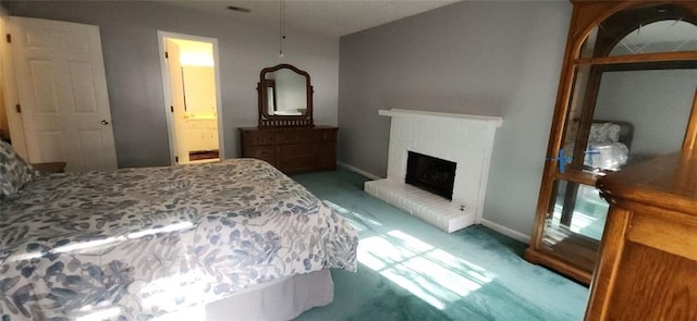 bedroom with baseboards, carpet floors, ensuite bathroom, and a fireplace