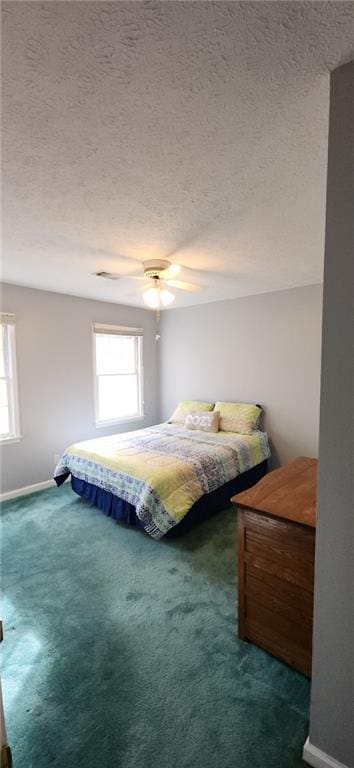 carpeted bedroom with a textured ceiling, baseboards, and ceiling fan