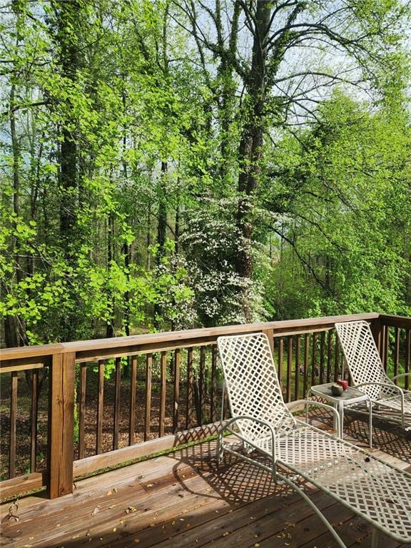 wooden deck with a wooded view