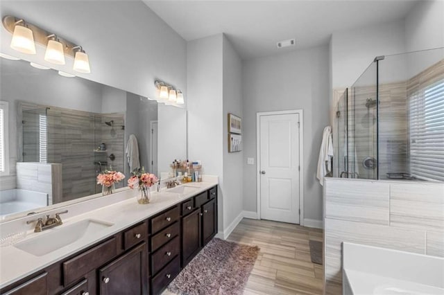 3717 Blue Goose Ln, Loganville, GA 30052 - bathroom with a bath, double vanity, a shower stall, and wood finished floors