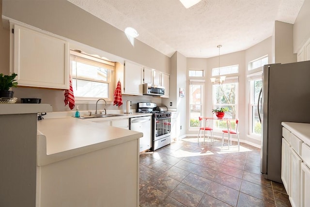 kitchen with white cabinetry, sink, decorative light fixtures, and appliances with stainless steel finishes