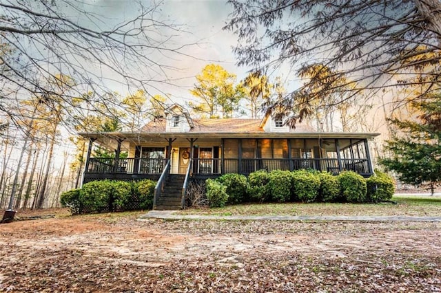 view of front of property featuring stairway and a sunroom