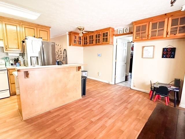 312 Henderson Mill Rd, Mansfield, GA 30055 - kitchen with a breakfast bar, light countertops, light wood-style flooring, stainless steel fridge, and white electric stove