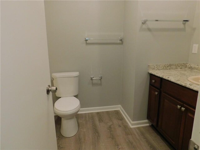 bathroom featuring hardwood / wood-style floors, vanity, and toilet