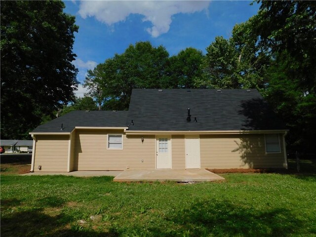 rear view of house with a lawn and a patio area