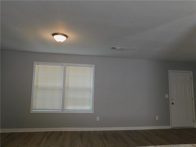 empty room with dark hardwood / wood-style flooring