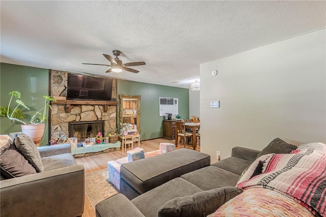 2642 Bridgehampton Rd SW, Marietta, GA 30064 - living area with ceiling fan, wood finished floors, a stone fireplace, and a textured ceiling