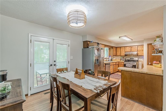 2642 Bridgehampton Rd SW, Marietta, GA 30064 - dining area with light wood-style flooring, french doors, and a textured ceiling