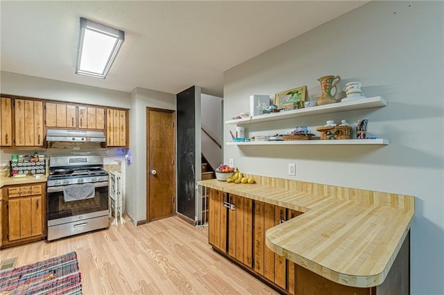 2642 Bridgehampton Rd SW, Marietta, GA 30064 - kitchen featuring stainless steel gas range, under cabinet range hood, light countertops, and brown cabinets
