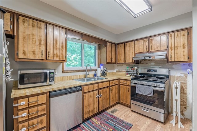 2642 Bridgehampton Rd SW, Marietta, GA 30064 - kitchen featuring appliances with stainless steel finishes, a sink, under cabinet range hood, and light countertops