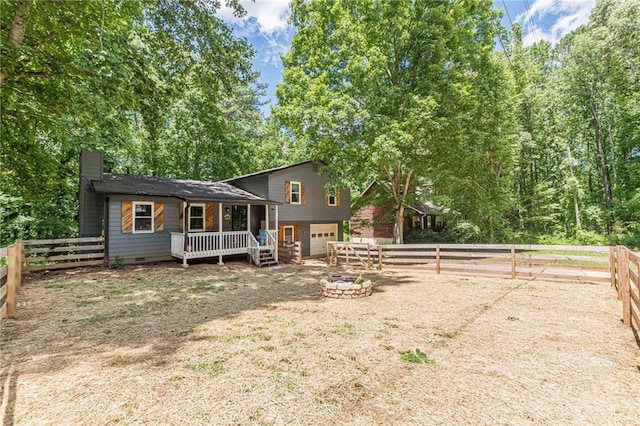 2642 Bridgehampton Rd SW, Marietta, GA 30064 - back of property featuring an attached garage, a chimney, crawl space, a fenced backyard, and an outdoor fire pit