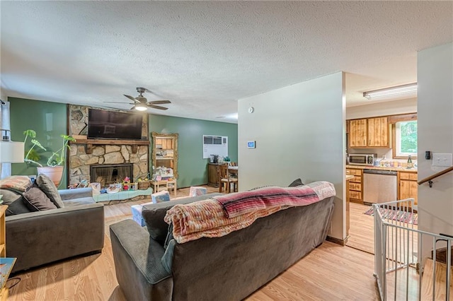 2642 Bridgehampton Rd SW, Marietta, GA 30064 - living area with ceiling fan, a textured ceiling, a stone fireplace, and light wood-style floors