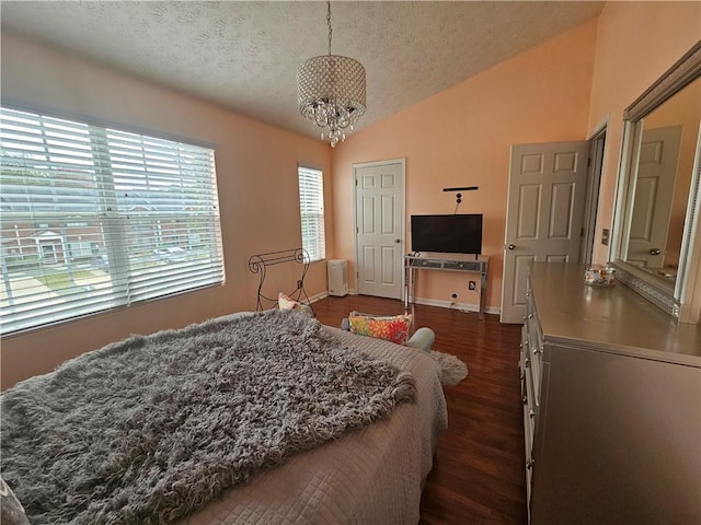 5536 Strathmoor Manor Cir, Lithonia, GA 30058 - bedroom with vaulted ceiling, a textured ceiling, dark wood-style floors, a chandelier, and baseboards