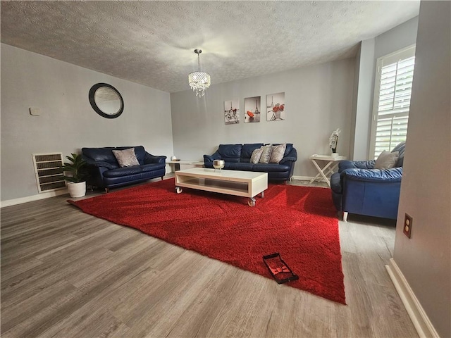 5536 Strathmoor Manor Cir, Lithonia, GA 30058 - living room with wood finished floors, baseboards, a chandelier, and a textured ceiling