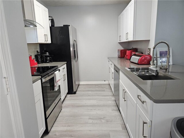 5536 Strathmoor Manor Cir, Lithonia, GA 30058 - kitchen with appliances with stainless steel finishes, a sink, light wood-style flooring, and white cabinetry