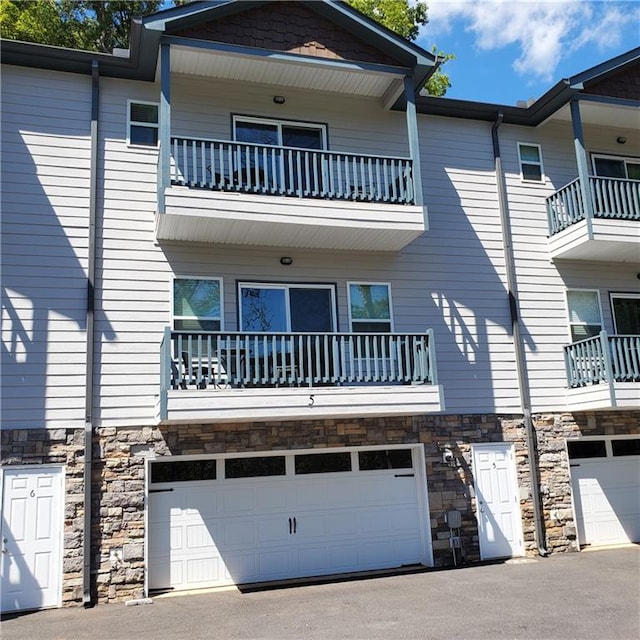 view of front of house featuring a garage and stone siding