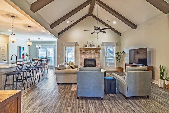 living area featuring high vaulted ceiling, beamed ceiling, dark wood-type flooring, and a fireplace