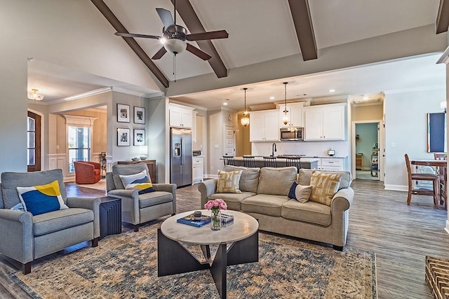 living room featuring baseboards, high vaulted ceiling, ceiling fan, ornamental molding, and beamed ceiling