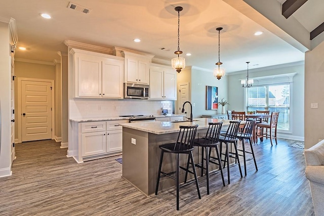 kitchen featuring decorative backsplash, white cabinets, visible vents, and stainless steel appliances
