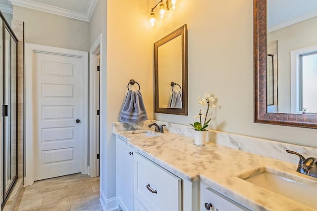 bathroom with a shower stall, ornamental molding, double vanity, and a sink