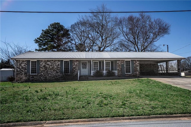 ranch-style house featuring metal roof, brick siding, concrete driveway, a carport, and a front lawn